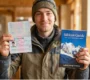 Traveler holding a passport with Indian visa and a Sikkim guidebook before a trip to Sikkim.
