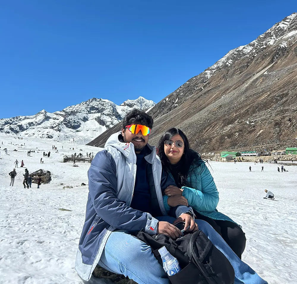 Couple enjoying a snowy mountain tour in Sikkim with Himalayan views