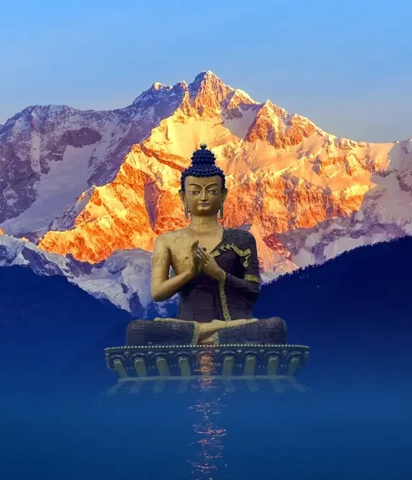 Golden sunrise light on Kanchenjunga behind a Buddha statue in Sikkim
