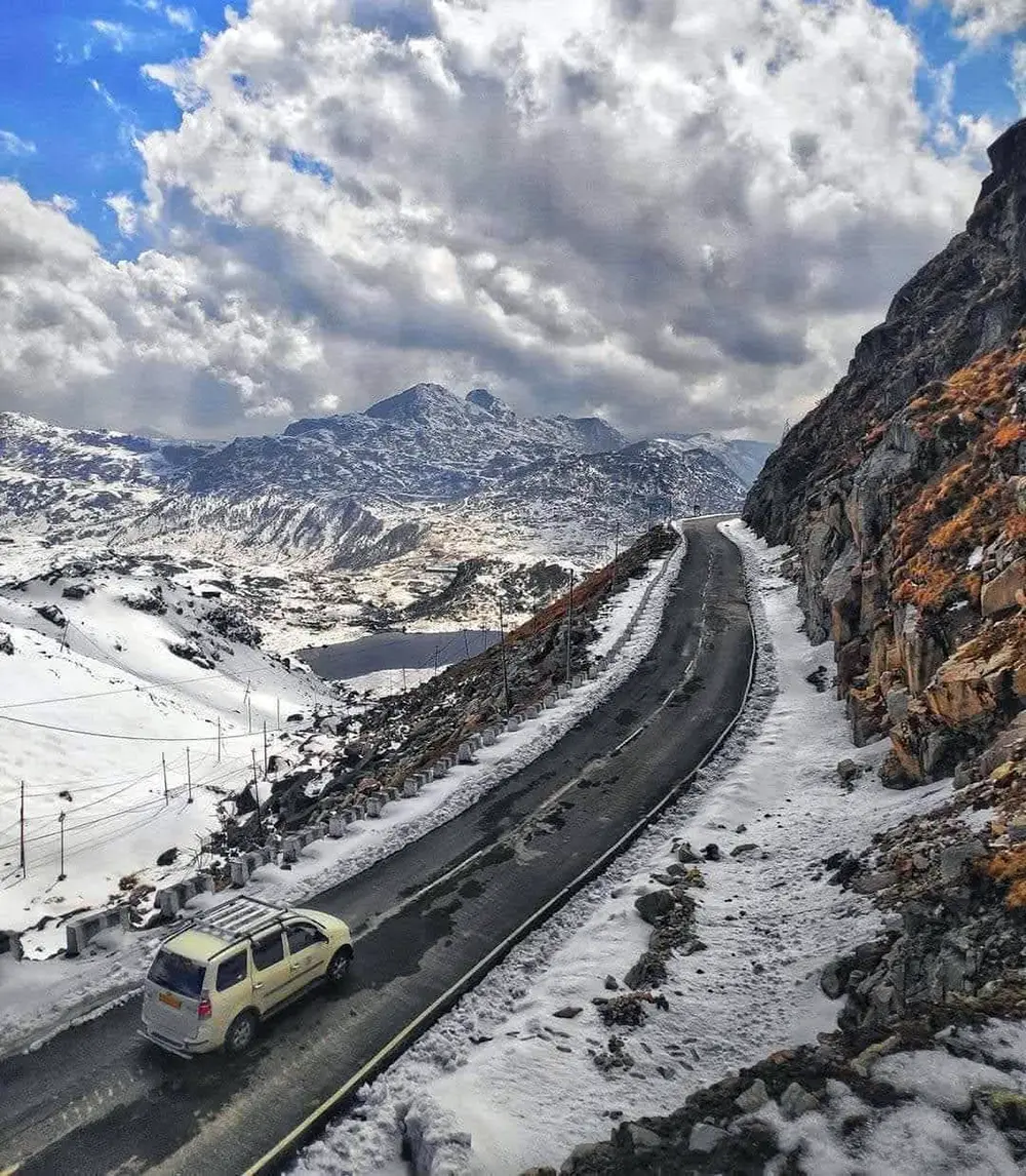 Vehicle on a snow-covered mountain road in North Sikkim during a Sikkim package tour